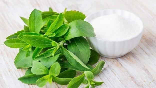 Hình ảnh một người đang thưởng thức đồ uống ngọt dùng cỏ ngọt với nụ cười